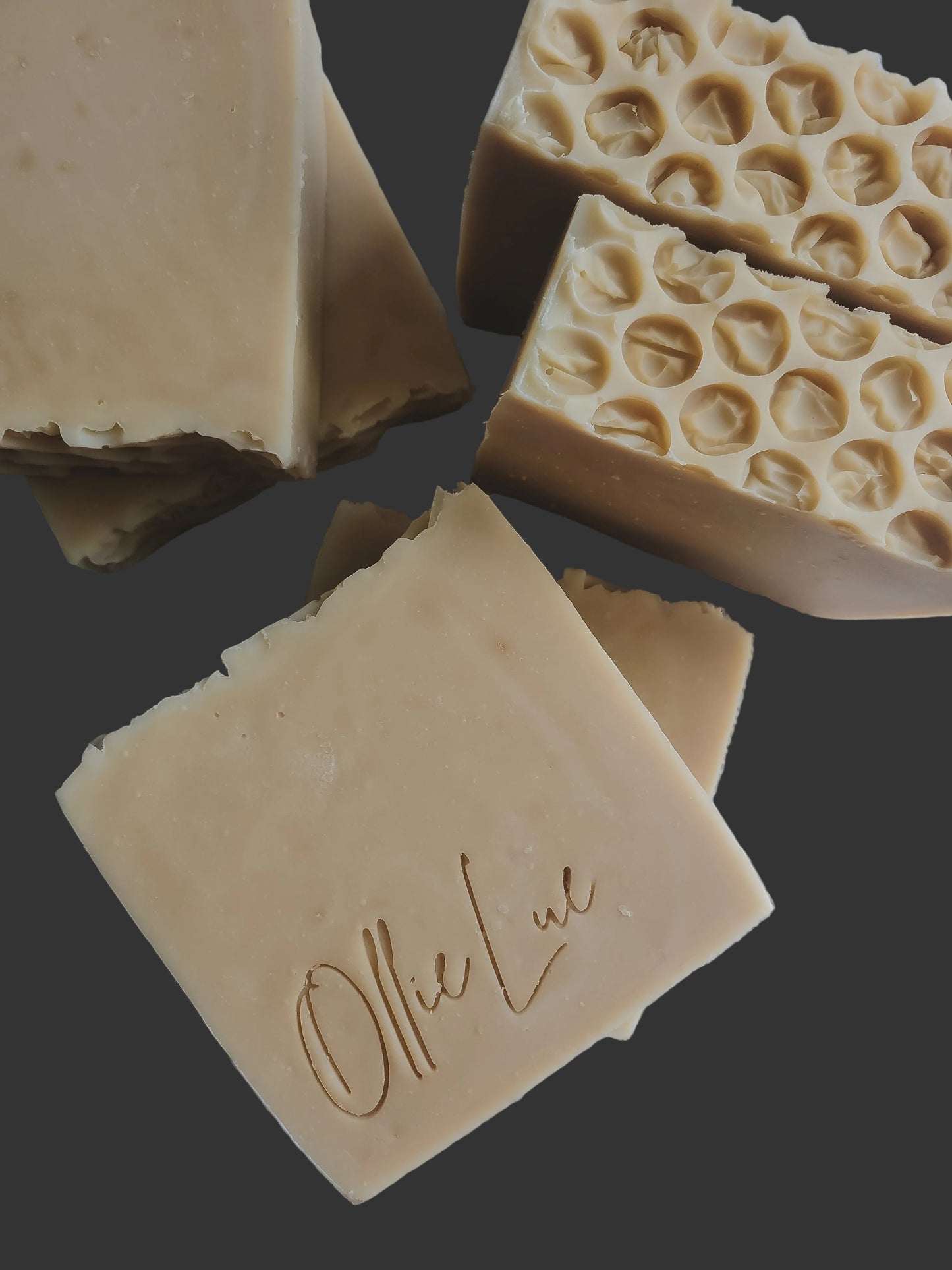 Four soap bars with different textures on a dark background, featuring the brand 'Ollie Lue'.