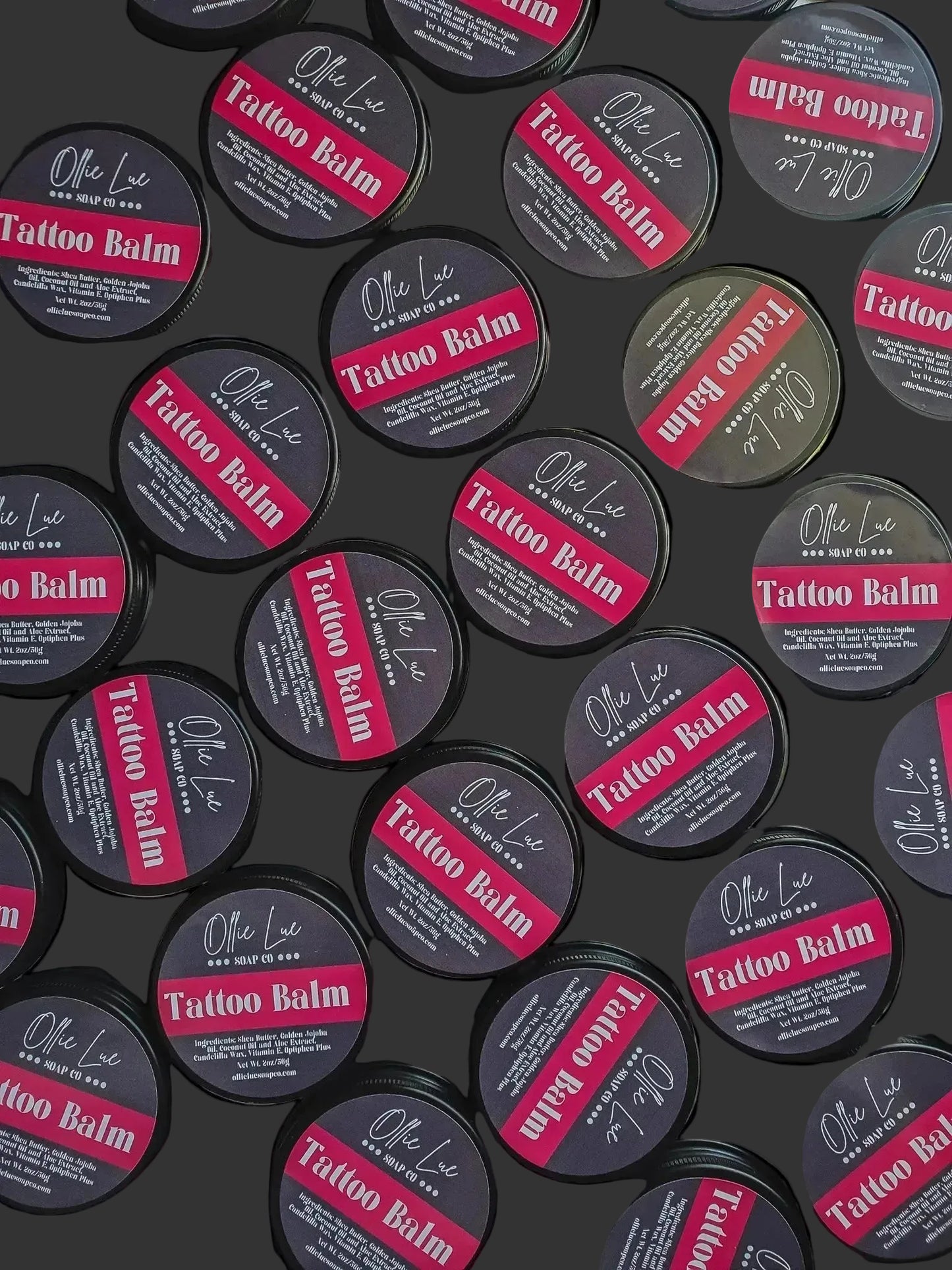 Multiple containers of Tattoo Balm with visible branding on a dark background