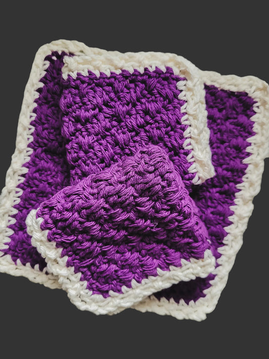 Purple and white crocheted blanket on a dark background