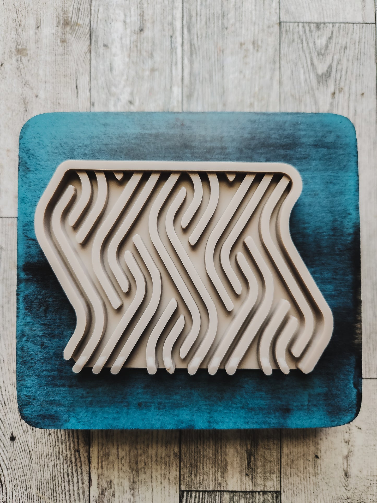 taupe soap dish on a blue wooden stand
