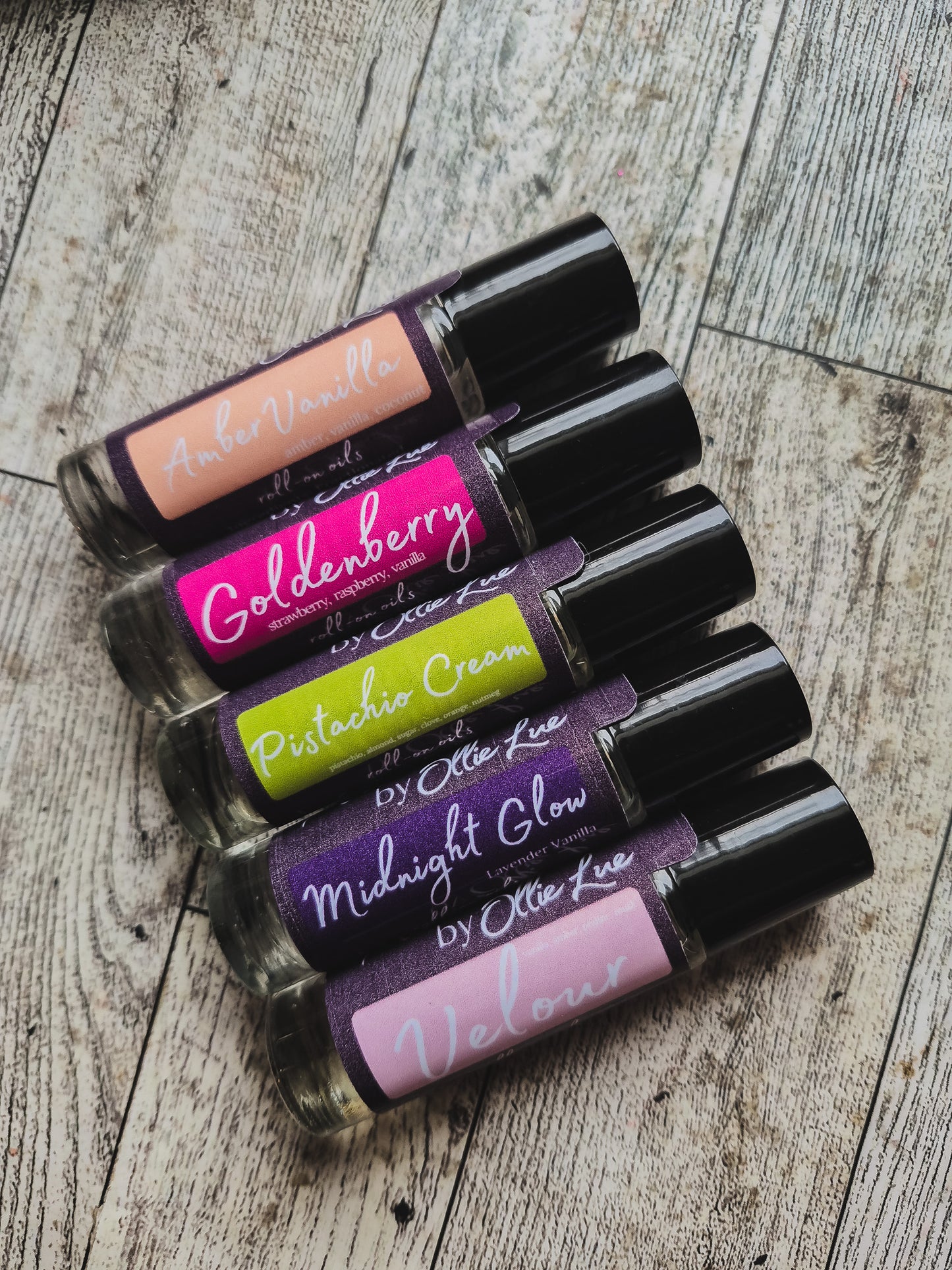 Set of scented oil tubes with visible brand names on a dark background