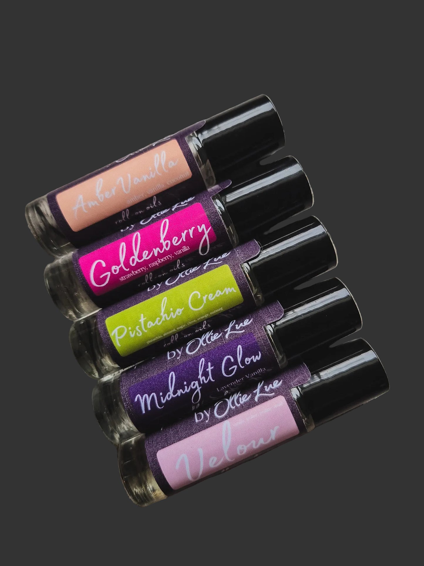 Set of scented oil tubes with visible brand names on a dark background
