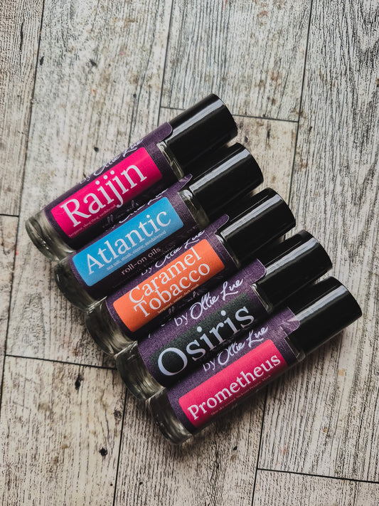 Set of scented oil tubes with colorful labels on a dark background