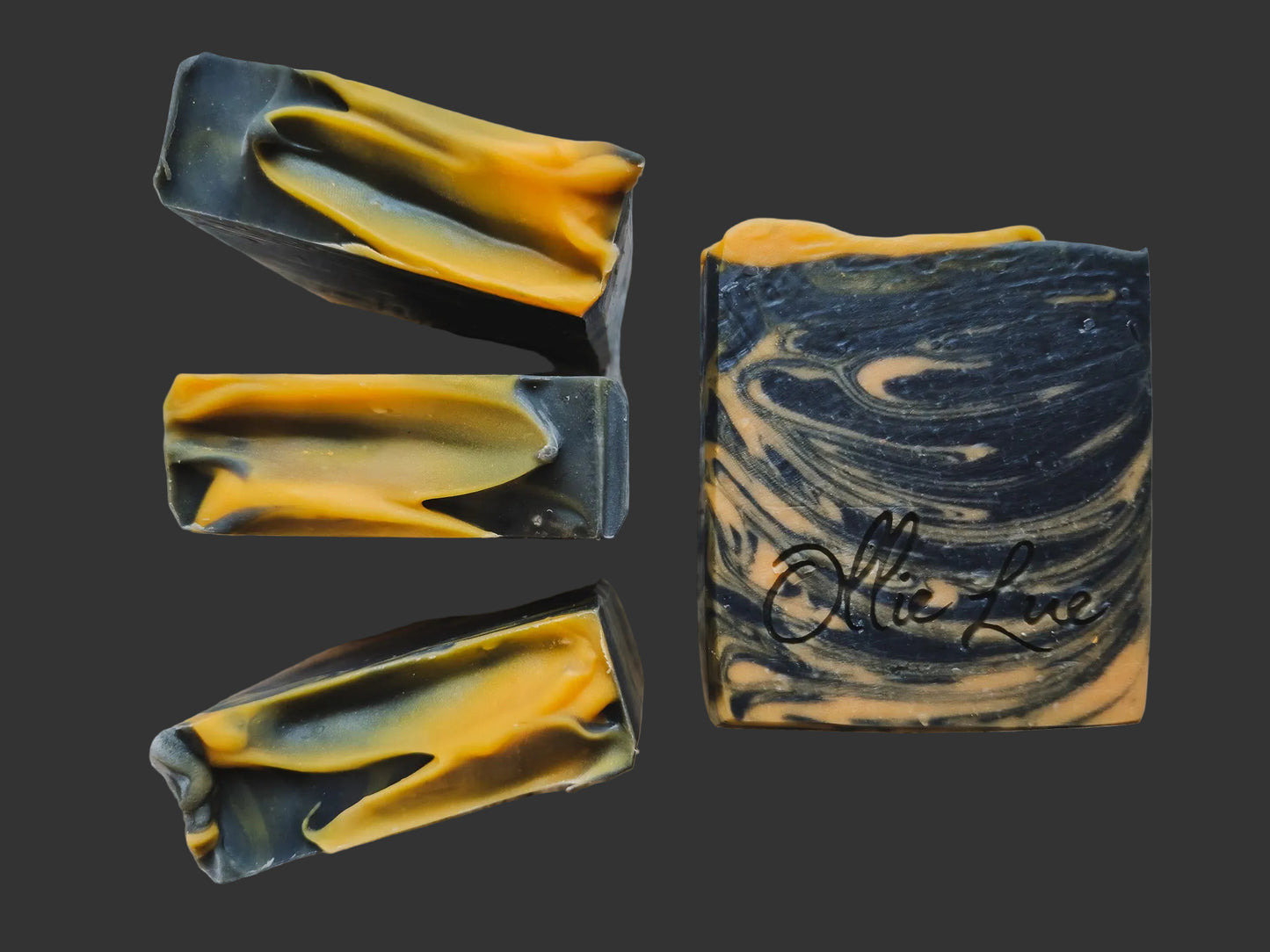 black and orange swirled soap stamped 'ollie lue' on a dark background