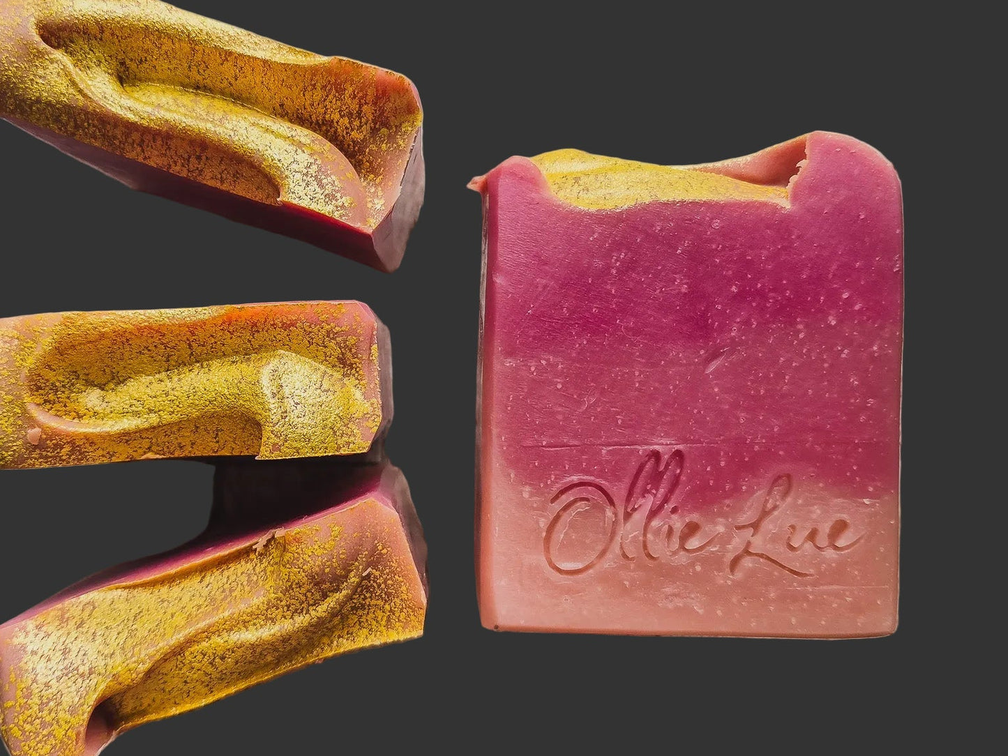 pink ombre soap stamped 'ollie lue' with gold tops on a dark background