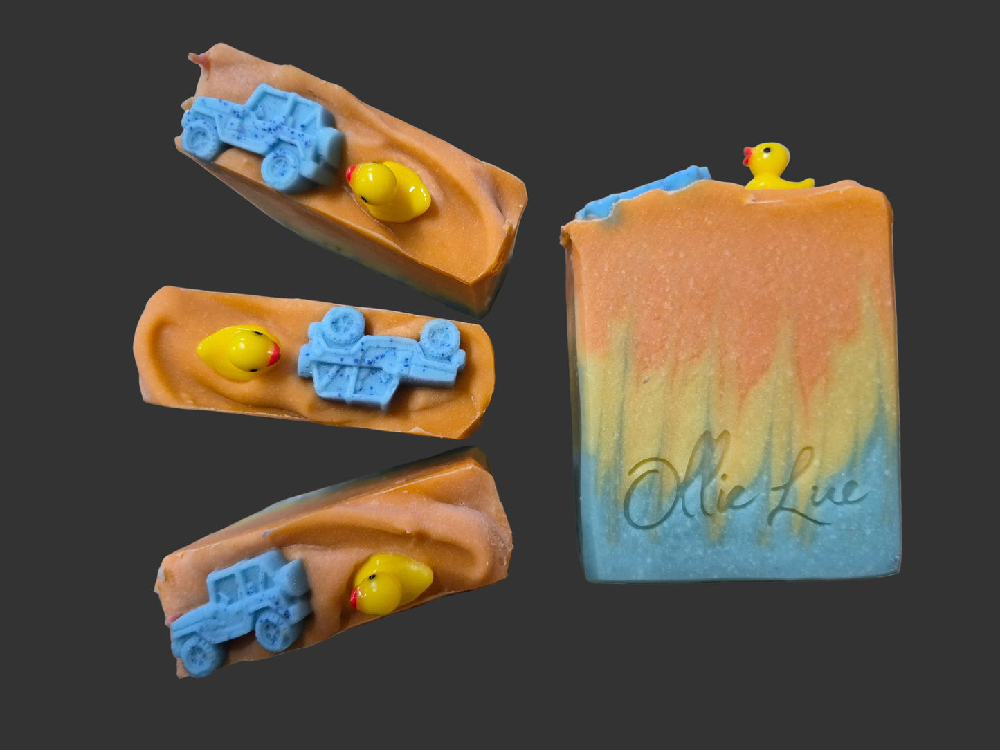 blue and orange soap topped with a jeep and a keep sake duck on a dark background
