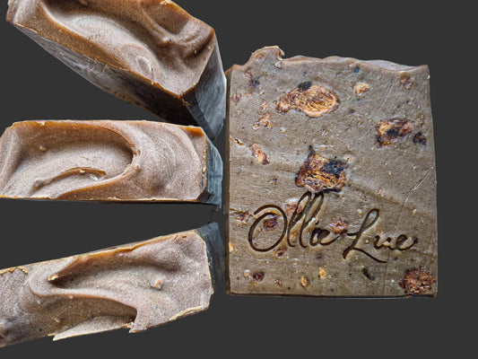 Close-up of a bar of soap with 'Ollie Lue' branding on a dark background