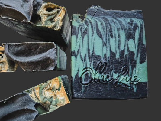 Close-up of a bar of soap with 'ollie lue' branding on a dark background