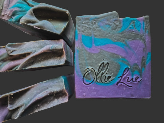 Colorful soap bar with 'Ollie Lue' branding on a dark background