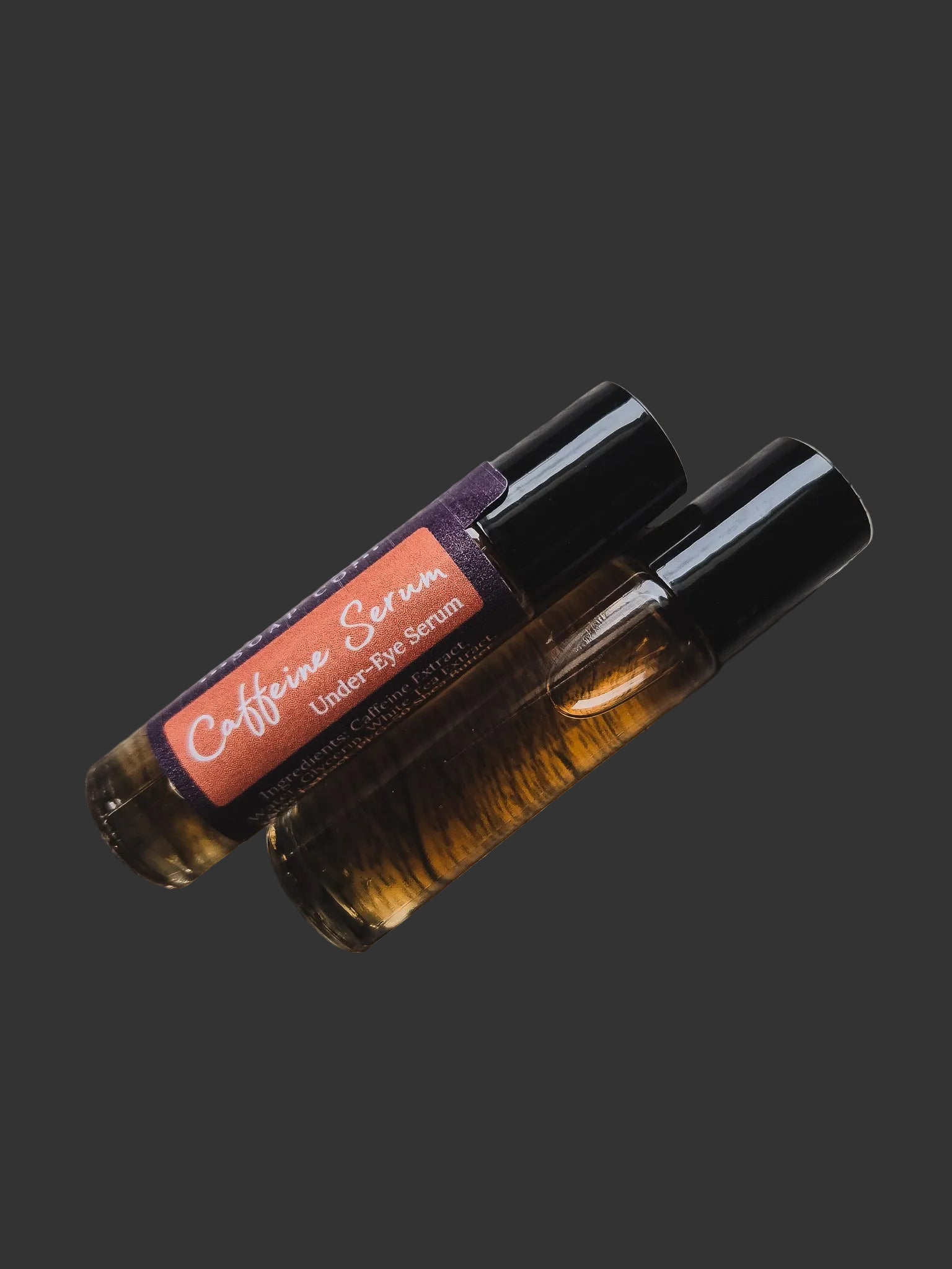 Two bottles of caffeine serum with a dark background