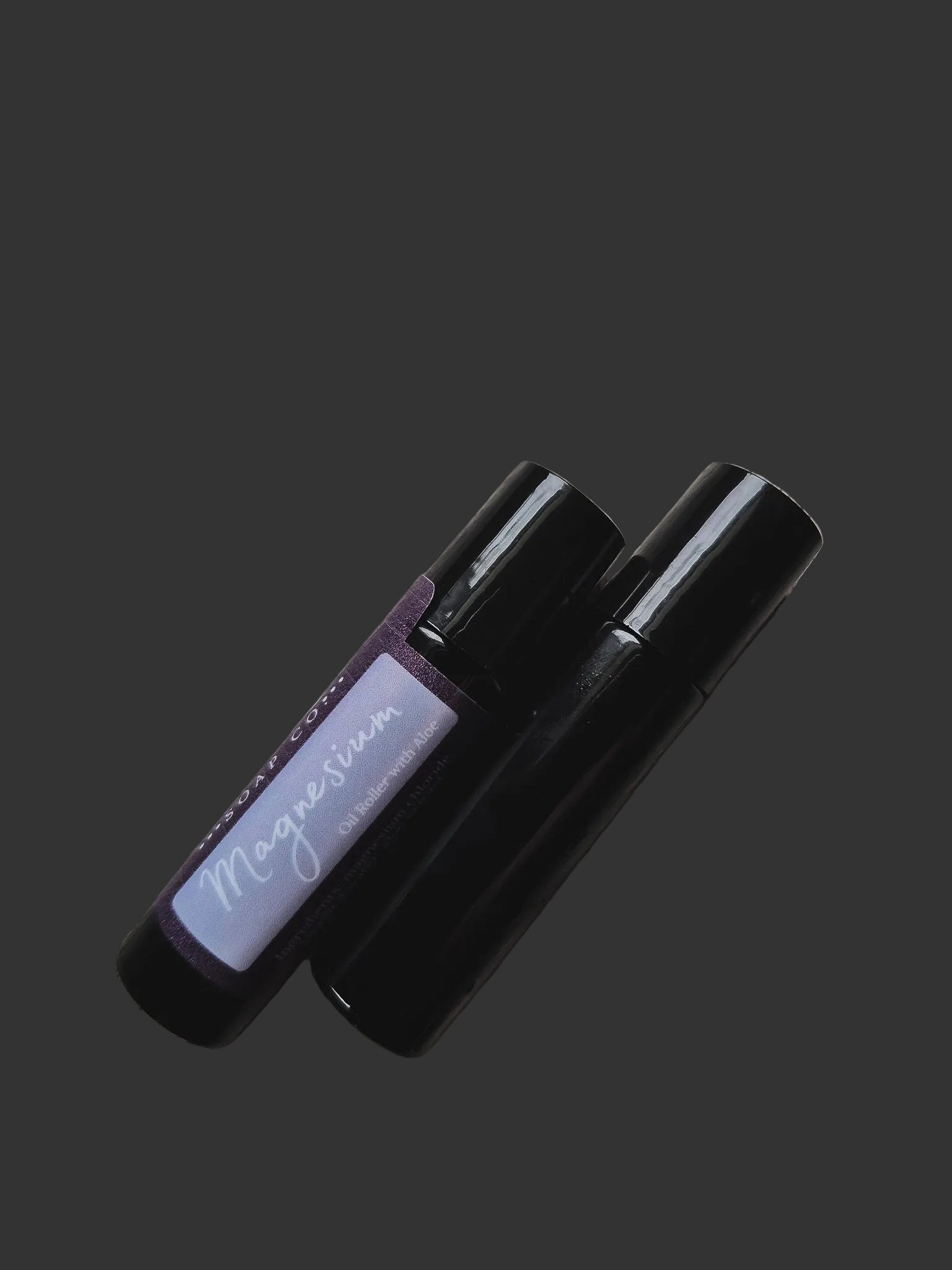 Two black perfume bottles with a visible brand label on a dark background