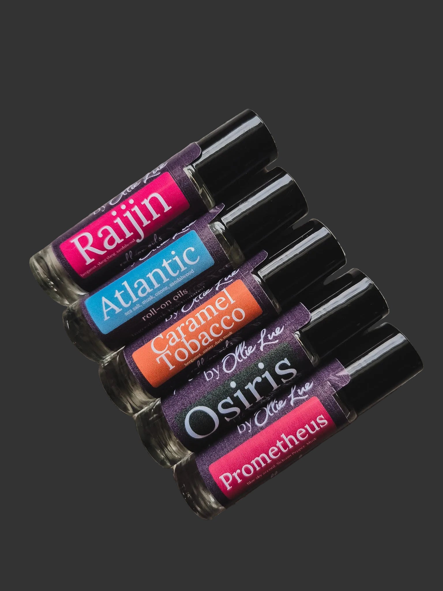 Set of scented oil tubes with colorful labels on a dark background