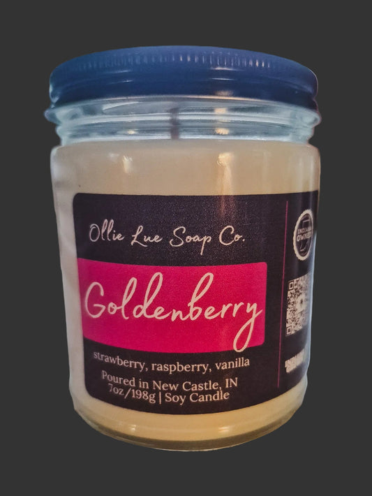 Jar of Goldenberry candle branded Ollie Lue on a dark background