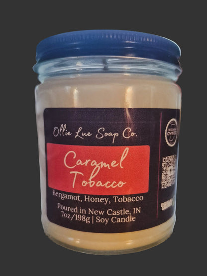 Jar of Caramel Tobacco candle with Ollie Lue Soap Co. label on a dark background