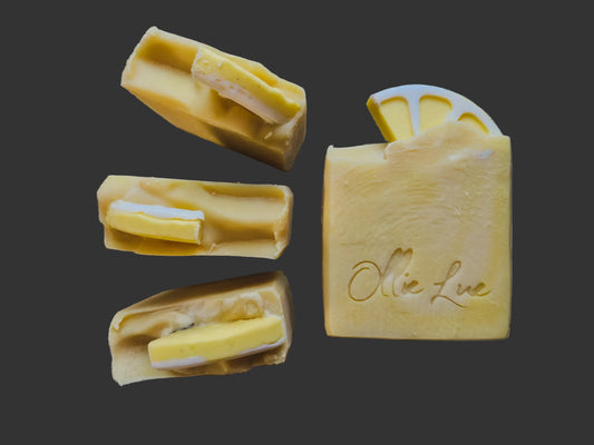 yellow soap with a soap lemon on top, stamped 'ollie lue' all on a dark background