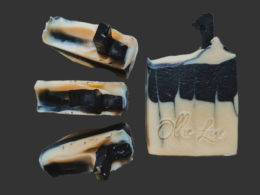 black and white soap designed to look like a piano, topped with a soap music note all on a dark background