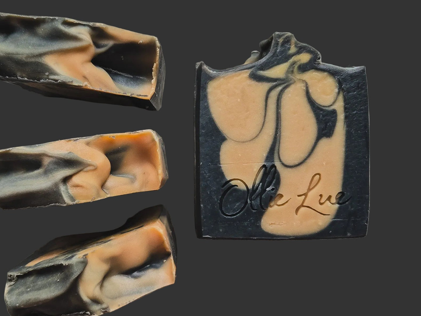 black and caramel colored soap stamped 'ollie iue' on a dark background