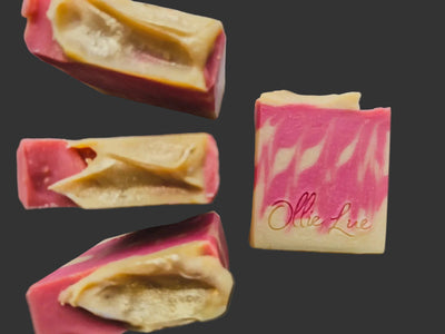 Colorful soap bars with a brand name on a gray surface