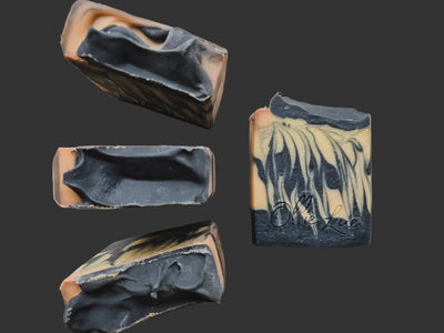 Four bars of soap with a marbled design on a beige surface