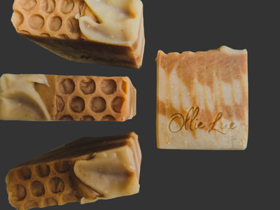 Close-up of soap bars with a textured surface and 'Ollie Lue' branding on a metallic background.