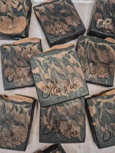 black and brown soap stamped Ollie Lue on a gray background
