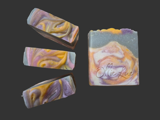 colorful orange, purple and white mountain bar soap stamped ollie lue on a dark background