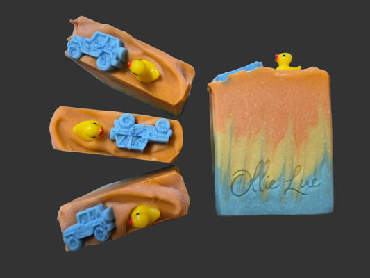 blue and orange soap topped with a jeep and a keep sake duck on a dark background