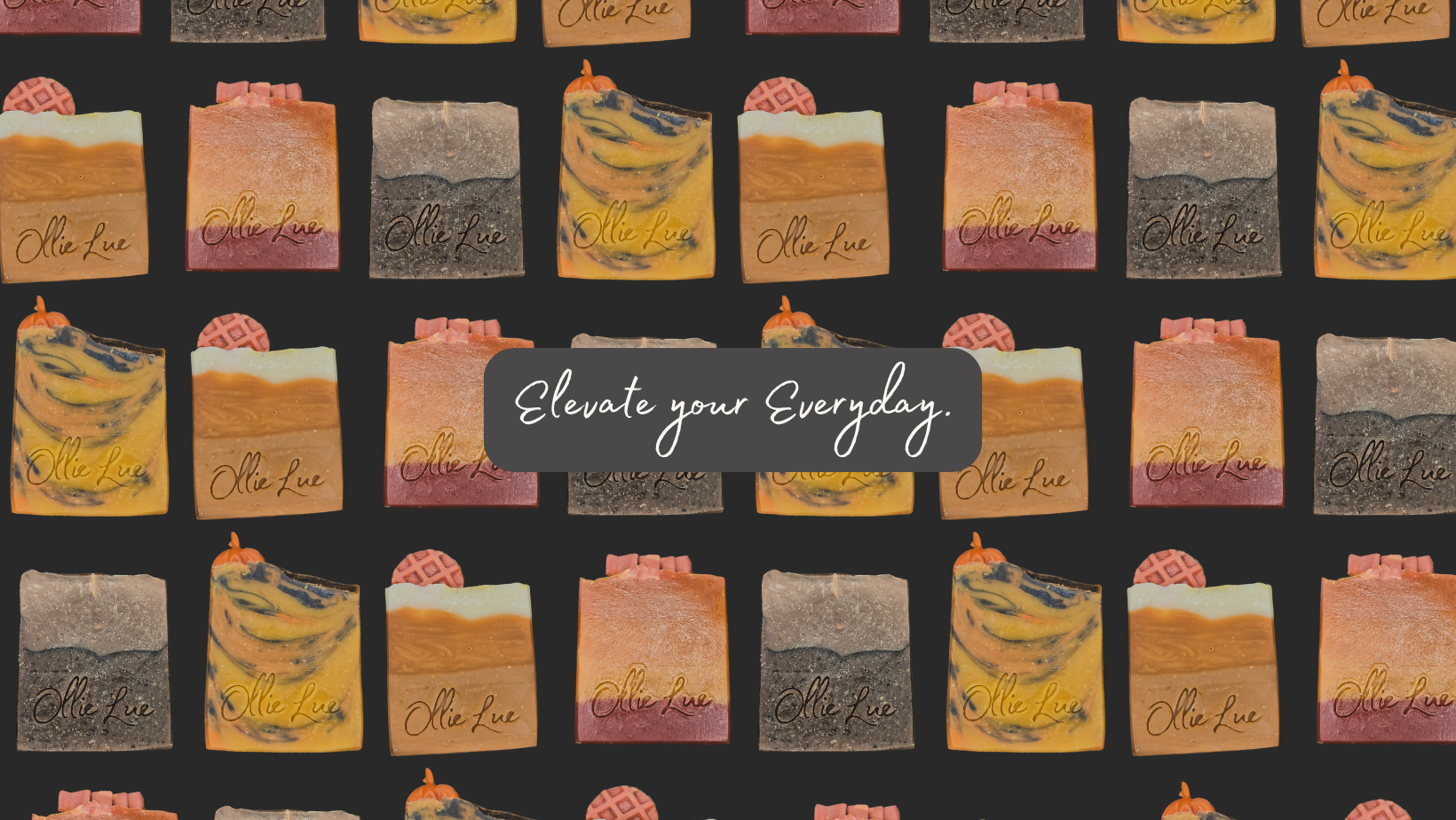 A repeating pattern of illustrated bath soaps in warm peach, yellow, and gray tones on a dark charcoal background, with a central dark label reading 'Elevate your Everyday.' The brand name 'Ollie Lue' appears on several soap illustrations.