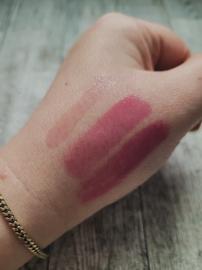 color swatch of lip gloss on hand on a wooden background